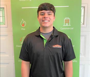 Devan standing in front of our SERVPRO banner